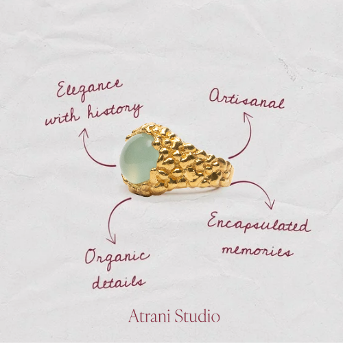Gold ring with a green gemstone on a textured white background, featuring the design of Atrani Studio, artisanal , organic details, gold plated jewerly 