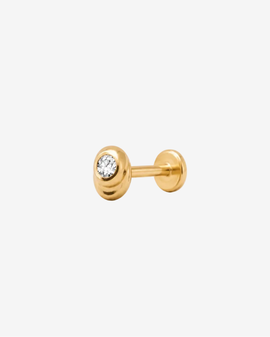 Gold stud earring with a central gemstone on a light gray background